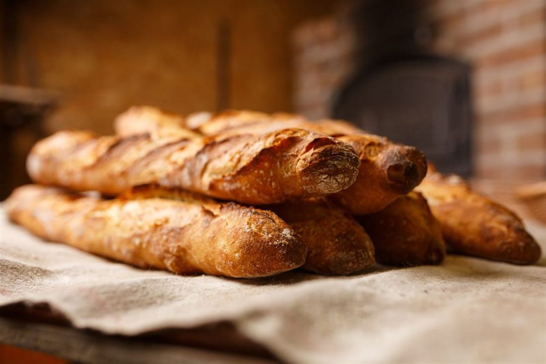 Fresh loaves of bread on a cloth beside the oven