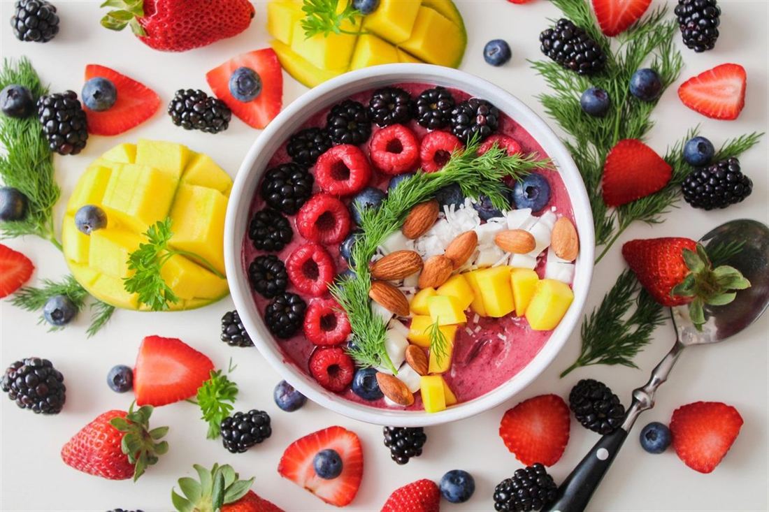 A bowl of creamy yoghurt topped with fresh fruit and berries